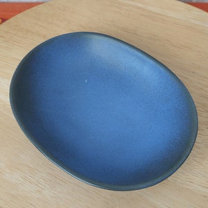 May include: A blue oval ceramic dish with a slightly textured surface.