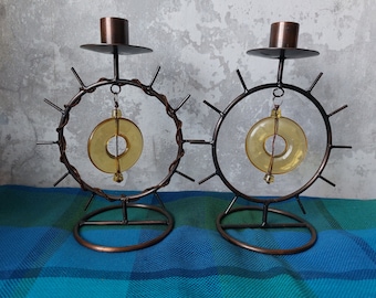 A pair of very beautiful stylish candlesticks made of metal and plastic, in the form of a symbolic sun.