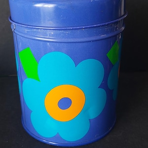 May include: A white ceramic mug with a black handle and the text "But First, Coffee" in a black, handwritten-style font. The mug is on a white surface.