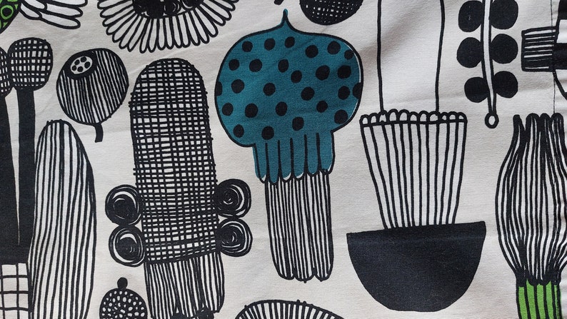 May include: Black and white fabric with a repeating pattern of stylized plants and flowers. The fabric features a teal blue flower with black polka dots.