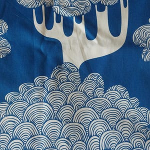 Puede incluir: Panel de cortina con estampado azul y blanco. El dise&ntilde;o presenta &aacute;rboles blancos estilizados con copas redondeadas y en capas sobre un fondo azul liso. La cortina tiene ojales met&aacute;licos en la parte superior para colgar.