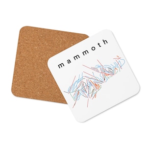 May include: White coaster with a black and white outline of a mountain range and the word "mammoth" in black text. The coaster is on top of a brown cork coaster.