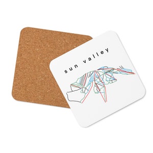 May include: White square coaster with a black and white outline of a mountain range and the text "sun valley" in black. The coaster has a cork backing.