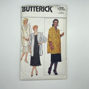 Op de afbeelding: Een naaipatroon voor een jas en een jurk in maat Large. Het patroon is van Butterick en het patroonnummer is 4158. De jas is geel met een zwart patroon en de jurk is zwart met witte stippen.