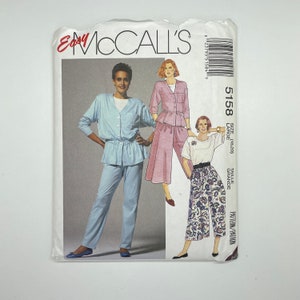 May include: A sewing pattern for a women's trousers and top set. The pattern is for size large (10-12) and is from McCall's Easy. The pattern shows three different styles of trousers and tops, all in light colours.