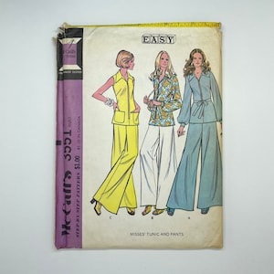Peut inclure: Patron de couture vintage McCall's pour une tunique et un pantalon pour femmes. Le patron est intitulé "Facile" et montre trois femmes portant différentes versions du vêtement. La tunique est sans manches et a une fermeture éclair sur le devant. Le pantalon est ample et a une ceinture.