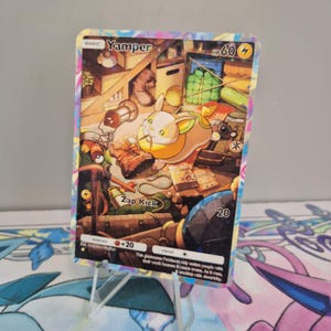 Könnte beinhalten: Eine YAMPER Pokémon-Sammelkarte mit einem farbenfrohen Rand. Die Karte zeigt eine Cartoon-Illustration eines hundeähnlichen Wesens mit gelbem und weißem Körper. Die Karte hat auch den Text "Zap Kick" und "HP 60".