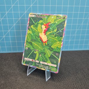 May include: A holographic Wurmple trading card featuring a green leaf background with star-shaped sparkles. The card displays the name Wurmple, 60 HP, a grass energy symbol, the attack Gnaw with 10 damage, and a fire weakness of +20.