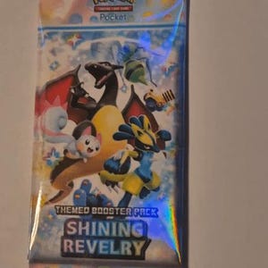 K&ouml;nnte beinhalten: Versiegelte Pok&eacute;mon Pocket Trading Card Game Boosterpackung. Die Packung hat ein holografisches Design mit verschiedenen Pok&eacute;mon-Charakteren, darunter Glurak und Lucario. Der Text "Shining Revelry" ist sichtbar.