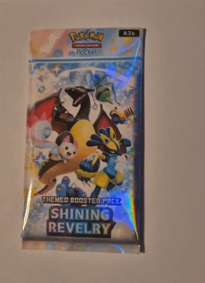 K&ouml;nnte beinhalten: Versiegelte Pok&eacute;mon Pocket Trading Card Game Boosterpackung. Die Packung hat ein holografisches Design mit verschiedenen Pok&eacute;mon-Charakteren, darunter Glurak und Lucario. Der Text "Shining Revelry" ist sichtbar.