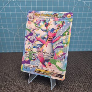 May include: A Mega Ampharos EX trading card featuring a colorful, holographic illustration of the character. The card displays the text Mega Ampharos EX, HP 210, Lightning Lancer, and various game statistics against a vibrant, star-filled background.