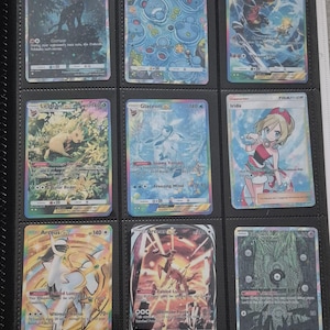 K&ouml;nnte beinhalten: Neun Pok&eacute;mon-Sammelkarten in einem Ordner. Die Karten zeigen verschiedene Charaktere und Designs, darunter Arceus, Garchomp und Glaceon. Die Karten befinden sich in Schutzh&uuml;llen, und der Ordner ist schwarz.