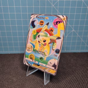Könnte beinhalten: Eine Pikachu EX Sammelkarte mit einer gelben Charakterillustration, 120 KP und dem Angriffstext Thunderbolt. Die Karte zeigt verschiedene bunte Energiesymbole, eine holografische Oberfläche und Spielregeln am unteren Rand.