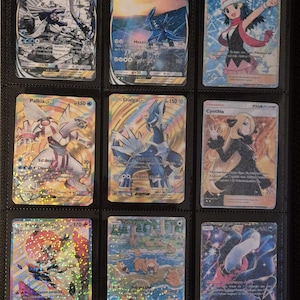 K&ouml;nnte beinhalten: Neun Pok&eacute;mon-Sammelkarten in einem Ordner. Die Karten zeigen verschiedene Charaktere und Kreaturen mit leuchtenden Farben und holografischen Effekten. Einige Karten zeigen Charakternamen wie Dialga, Palkia und Cynthia, mit Text und Zahlen.