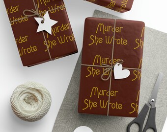 Puede incluir: Tres cajas de regalo marrones envueltas en papel con las palabras "Murder She Wrote" impresas en amarillo. Las cajas están atadas con cuerda y decoradas con estrellas y corazones blancos.