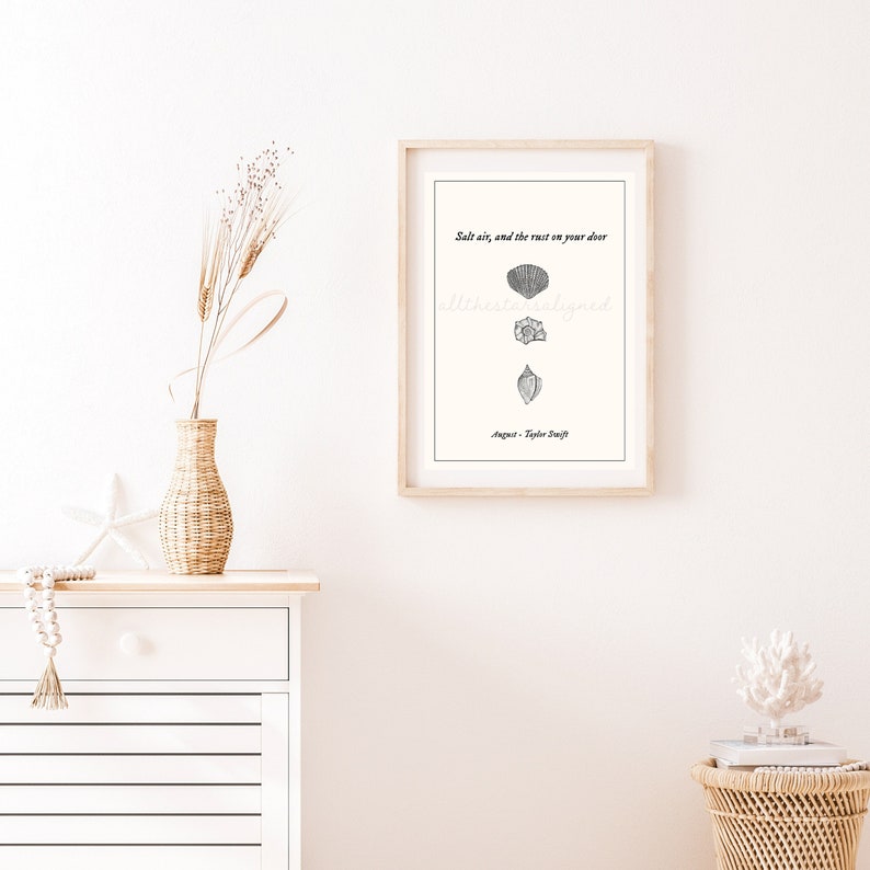 May include: A printable wall art design with a quote about salt air and the rust on your door. The quote is attributed to Taylor Swift. The design features a series of hand-drawn seashells.