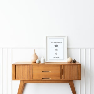 May include: A white framed print with the text "Salt air, and the rust on your door,  still smells like home."  The print is sitting on a wooden console table with two drawers. There are three decorative vases on the table.
