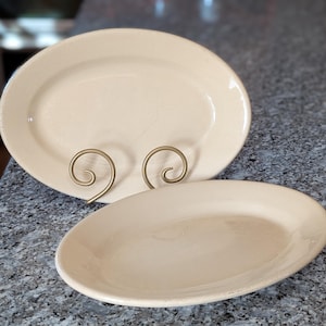 May include: A set of three ceramic mugs with a speckled, matte finish. The mugs are in shades of cream, light gray, and dark gray. Each mug has a simple, minimalist design, perfect for coffee or tea.