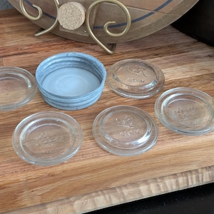 May include: A set of three ceramic canisters with lids. The canisters are white with a blue floral pattern. The largest canister is 8 inches tall, the medium is 7 inches, and the smallest is 6 inches.