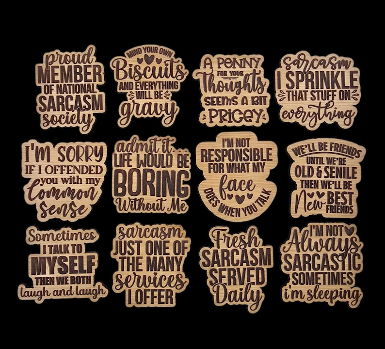 May include: A collection of twelve wooden laser-cut signs with humorous quotes about sarcasm and friendship. The signs feature various shapes and fonts, with phrases like "Proud Member of National Sarcasm Society" and "Fresh Sarcasm Served Daily."