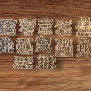 Pu&ograve; includere: Un set di 10 adesivi in legno marrone con frasi divertenti. Le frasi includono "Sarcasmo, solo uno dei tanti servizi che offro", "Esercizio? Pensavo avessi detto patatine fritte extra", "Apparentemente siamo problemi quando stiamo insieme", "Tutti i miei pantaloni sono sfacciati", "Se solo il sarcasmo bruciasse calorie", "Credeva di potercela fare, ma era davvero stanca, quindi non lo ha fatto", "Ho messo alla prova la mia pazienza, sono negativa", "Quando la vita mi d&agrave; limoni, prendo la vodka e chiamo le mie ragazze", "Metto il pro in procrastinare", e "Voglio tacos, non la tua opinione".