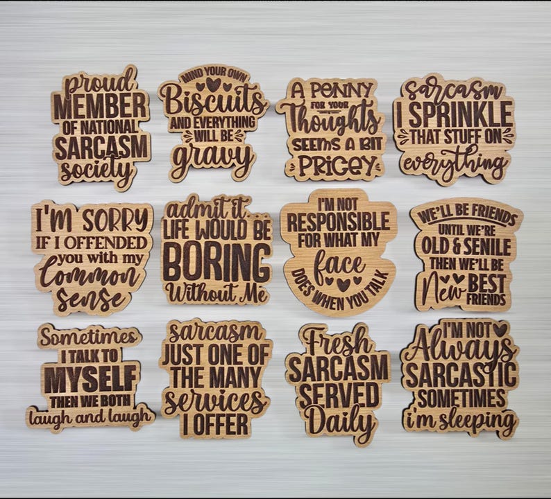 May include: A collection of twelve wooden plaques with humorous sayings in a variety of fonts. The plaques are light brown with dark brown text, featuring phrases like "Proud Member of National Sarcasm Society" and "Fresh Sarcasm Served Daily."