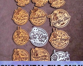 May include: A set of 12 round wooden coasters with various humorous sayings and designs. The coasters feature a variety of fonts and styles, including a skull and crossbones, a peace sign, and a coffee cup.