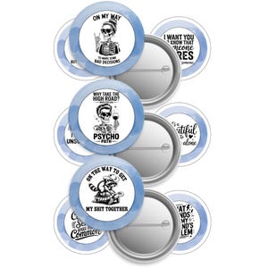 May include: A collection of round, blue and white pinback buttons with humorous phrases and skeleton graphics. The buttons feature phrases like "On My Way to Make Some Bad Decisions" and "Take the Psycho Path."