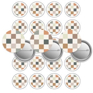 May include: A selection of round pin badges featuring a chequered pattern in beige, brown, green, and grey. The badges have a silver metal backing and a safety pin fastening. The design is repeated across multiple badges.