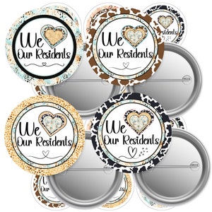 May include: Several round pin badges with the text "We Our Residents" in black script. Each badge has a heart design and a decorative border with cowhide, turquoise, and gold patterns. The badges have a silver metal backing.