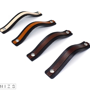 Può includere: Quattro maniglie per cassetti in pelle di diversi colori: beige, marrone, marrone scuro e nero. Ogni maniglia ha una vite argentata.