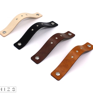 May include: Four leather handles with silver rivets. The handles are in different colors: beige, black, brown, and tan.