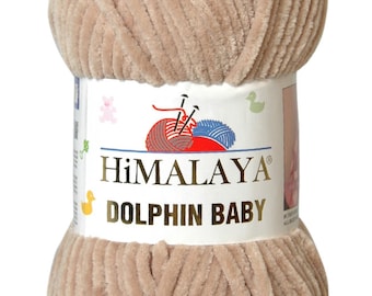 May include: A skein of beige Himalaya Dolphin Baby yarn. The yarn is soft and fluffy, perfect for knitting or crocheting baby blankets, sweaters, and other items.