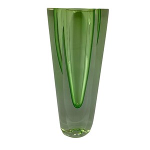 May include: A green glass vase with a clear glass base and a unique, angular design.