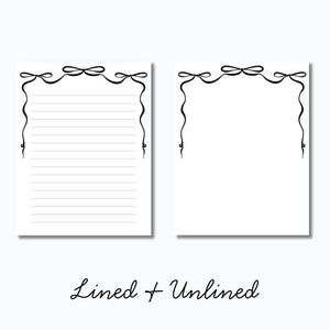 Op de afbeelding: Twee witte notitieblokken, &eacute;&eacute;n gelijnd en &eacute;&eacute;n ongelijnd, met een zwart lintontwerp langs de boven- en zijkanten. De tekst "Lined + Unlined" is in cursieve letters onderaan de afbeelding geschreven.