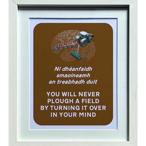 Peut inclure: Impression encadrée avec un cadre blanc. L'impression présente un fond marron avec un graphique de cerveau et un tracteur. Le texte en anglais et en gaélique irlandais se lit "YOU WILL NEVER PLOUGH A FIELD BY TURNING IT OVER IN YOUR MIND."