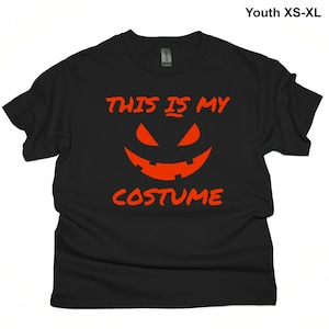 May include: Black youth t-shirt with the text "This is my costume" in orange with a jack-o-lantern face.