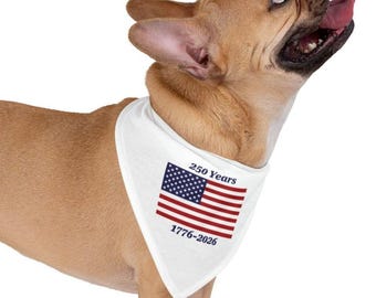 May include: A tan French Bulldog wearing a white bandana with the American flag and the text "250 Years 1776-2026". The dog is looking up with its tongue out.