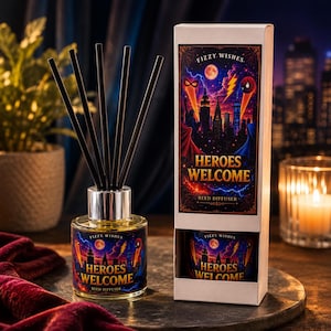 May include: A reed diffuser with a clear glass bottle containing yellow liquid, topped with five black reeds. The bottle and its white rectangular box feature a graphic of a city skyline at night with the text "Fizzy Wishes" and "Heroes Welcome".