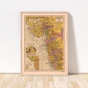 May include: A vintage-style map print of the Bombay Presidency in a light wood frame. The map features yellow, pink, and tan colour blocks, black text, and an inset illustration of the Gateway of India. The map includes the Arabian Sea label.