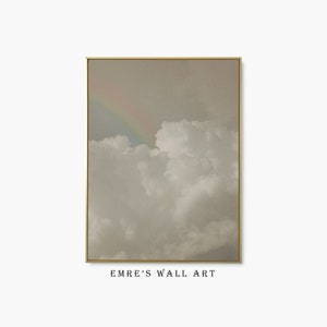 Puede incluir: Una impresión enmarcada de una fotografía de un cielo nublado con un arcoíris en la distancia. El cielo es de color gris claro y las nubes son blancas. El arcoíris es de un color pastel suave.