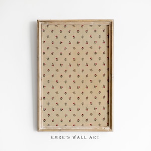 Könnte beinhalten: Ein gerahmter Druck mit beigefarbenem Hintergrund und einem sich wiederholenden Muster aus kleinen roten und grünen Blumen. Der Rahmen ist in hellem Holz gehalten und hat ein schlichtes Design. Der Text "EMRE'S WALL ART" ist unter dem Rahmen gedruckt.