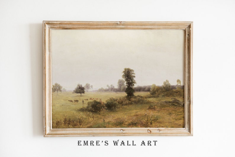 May include: A framed painting depicting a rural landscape with a field, trees, and a group of cows in the distance. The sky is a soft, muted gray, and the overall tone of the painting is peaceful and serene.
