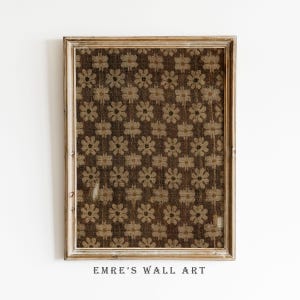 Può includere: Una stampa incorniciata di arte murale con un motivo floreale ripetuto in tonalità marrone e beige. L'opera d'arte è racchiusa in una cornice di legno marrone chiaro invecchiato. Il testo "EMRE'S WALL ART" è stampato in basso.