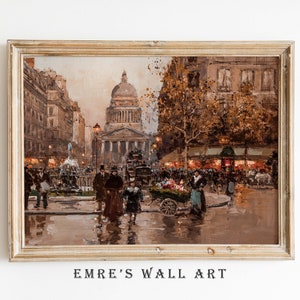 May include: A framed vintage-style print of a European city scene. The artwork depicts a bustling street with people, buildings, and a large domed structure in the background. The color palette is dominated by warm browns and golds, with the text "EMRE'S WALL ART" at the bottom.