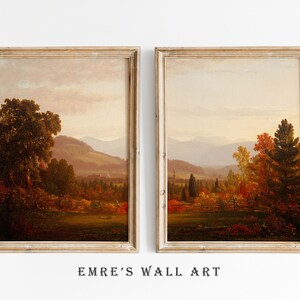 May include: Two framed landscape paintings depicting autumn scenes with rolling hills, trees, and a distant town. The paintings are in a rustic style with warm colors.