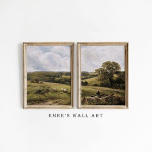 May include: Two framed landscape paintings with a rustic aesthetic. The paintings depict rolling hills, trees, and a cloudy sky. The frames are a light wood color.