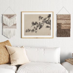 A vintage Japanese ink wash painting of a pine tree branch with detailed pine needles and a small pinecone against a textured beige paper background. The elegant black brushstrokes capture a minimalist, traditional East Asian artistic look. A small red artist seal is visible in the bottom right corner.