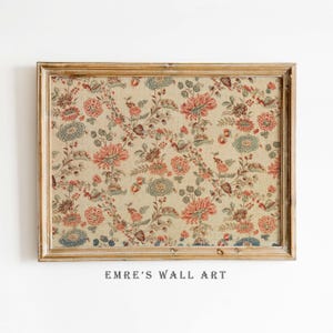Puede incluir: Una impresión floral enmarcada con un fondo beige y un patrón repetido de flores y hojas rojas, azules y marrones. El marco es de color marrón claro. El texto "EMRE'S WALL ART" está impreso en la parte inferior.