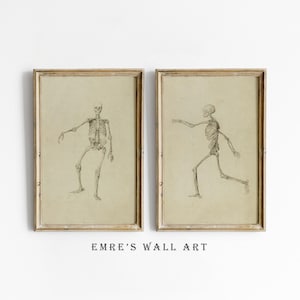 May include: Two framed vintage-style prints featuring skeletal figures in motion. The drawings are in black ink on a beige background, with gold-colored frames. The text "EMRE'S WALL ART" is printed at the bottom.